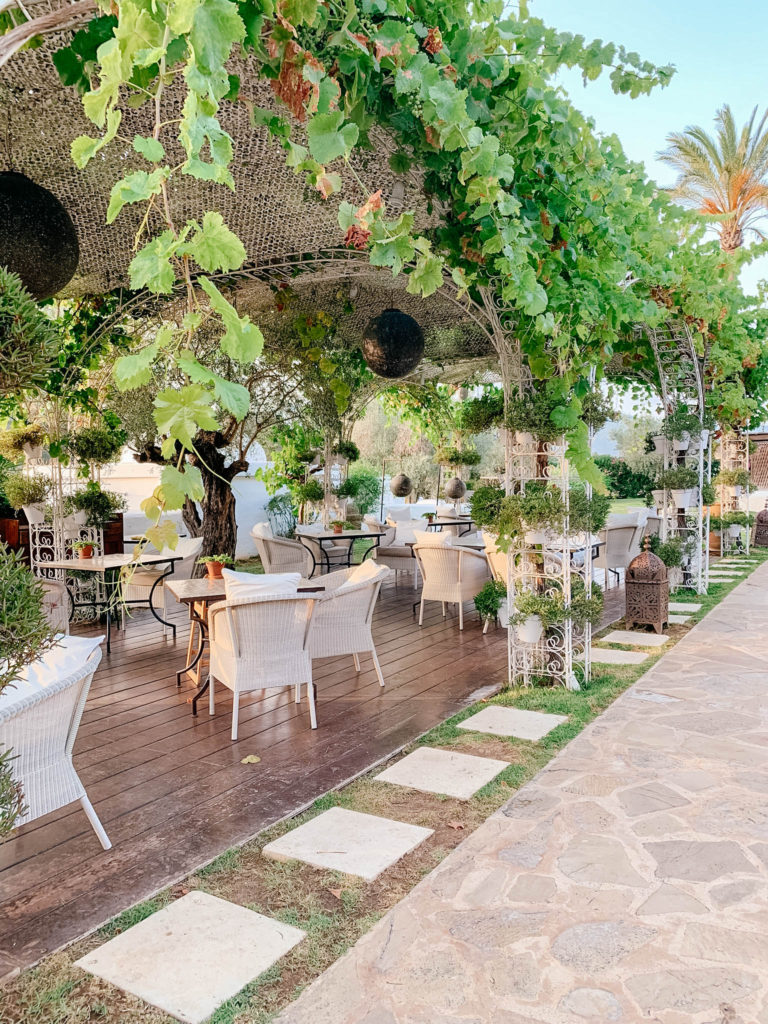 Dining area in lush green setting at Atzaro Spa in Ibiza